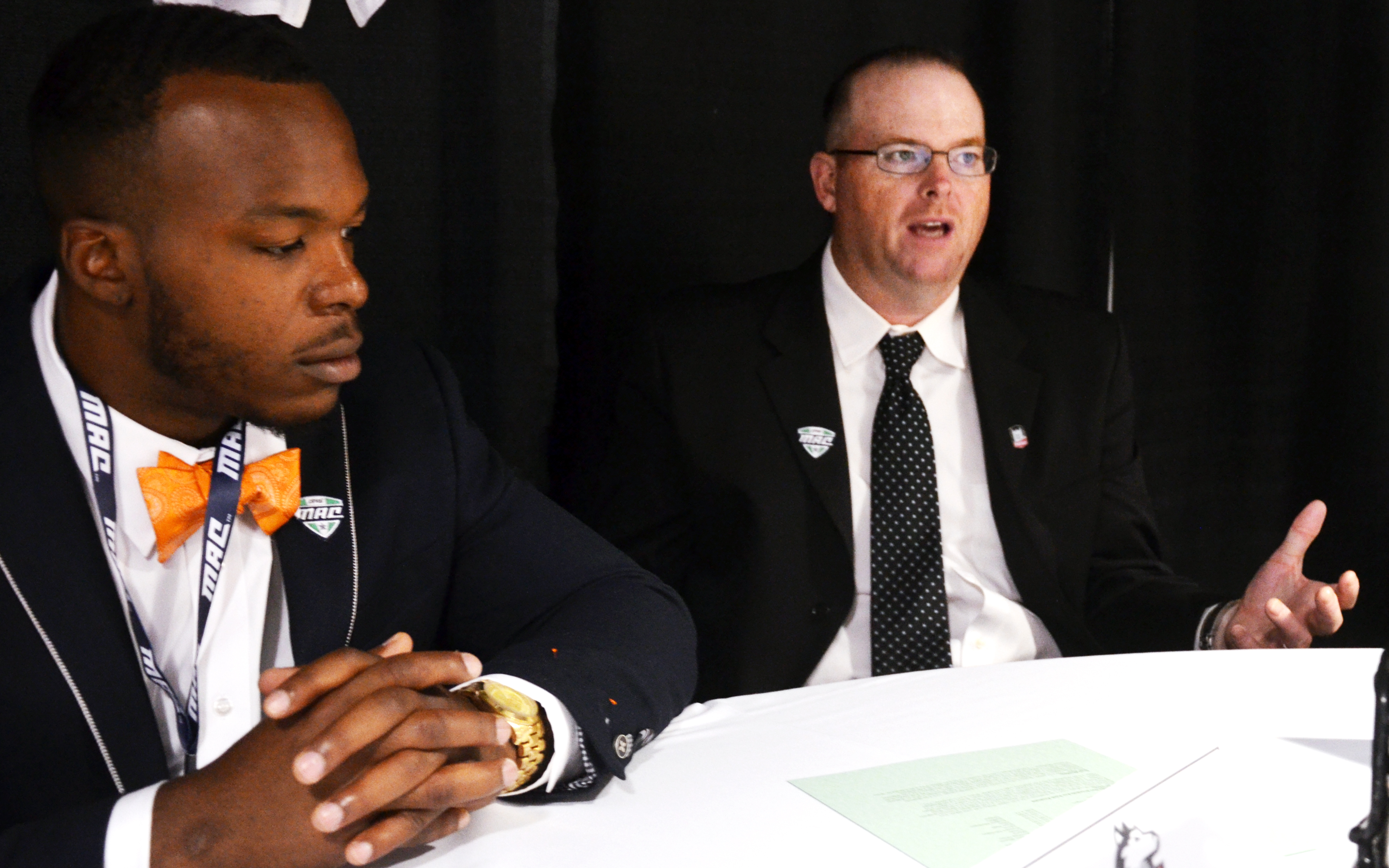 CFB HUDDLE/Brandon Folsom -- Northern Illinois second-year coach Rod Carey (right) speaks with reporters, along with senior running back Cameron Stingily, during MAC Media Day on Wednesday, July 23, 2014, at Ford Field in Detroit.